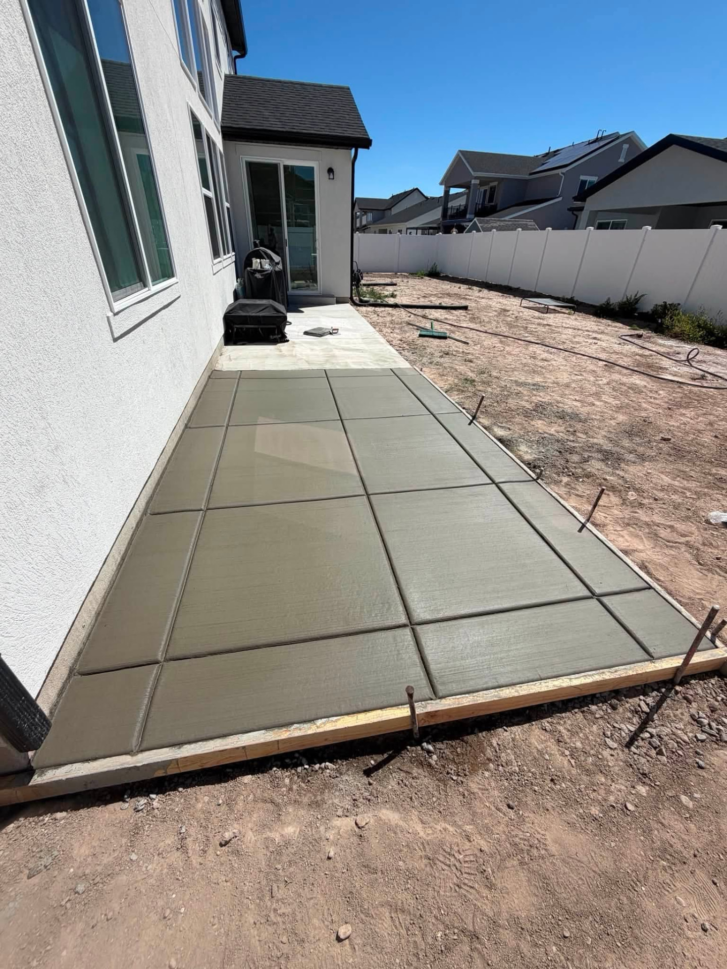 Freshly poured concrete patio with a precise grid of control joints