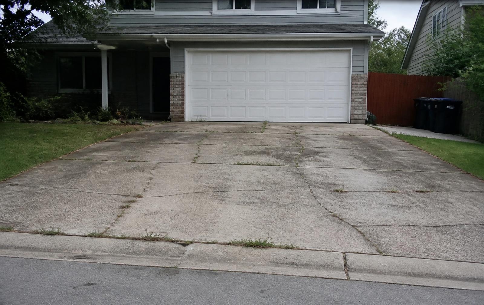 Worn, cracked concrete driveway before replacement